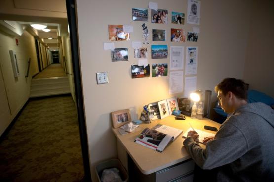 student at their desk in a room with door open to hallway