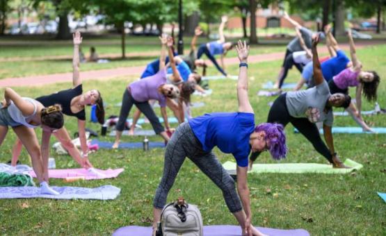 People performing yoga on the College Green
