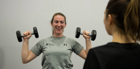 Young woman lifting weights.