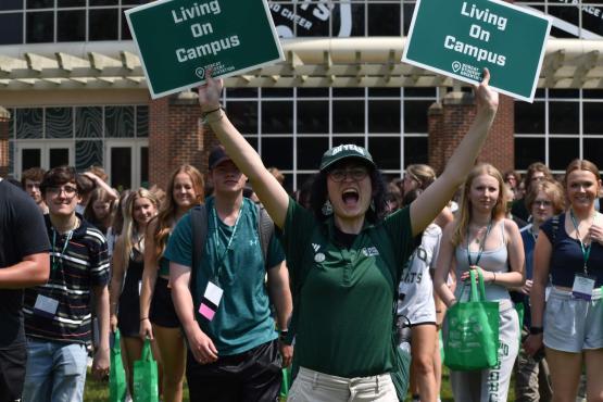 Orientation leader holding signs and leading students