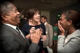 Jenny Hall-Jones laughs with former President McDavis and another person during a celebration.