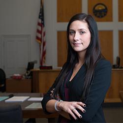 A law student poses in a courtroom