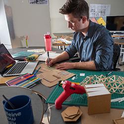 Interior architecture student works on sketches at a desk