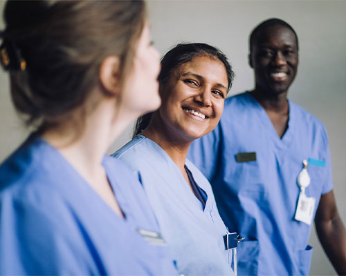 Post-Graduate Emergency Nurse Practitioner Certificate students smiling in medical scrubs. Group of future Nurse Practitioners.