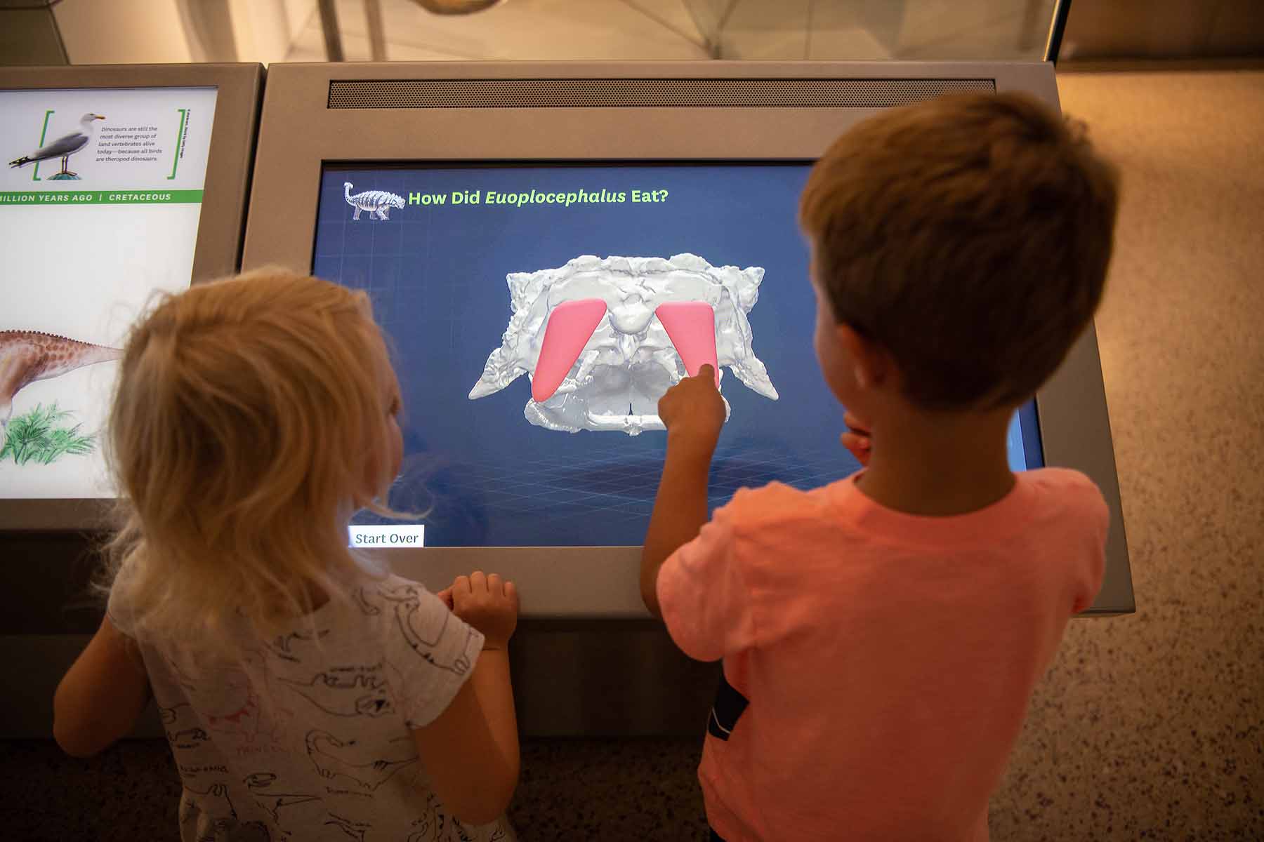 Children interacting with a computer simulation at the Smithsonian dinosaur exhibit