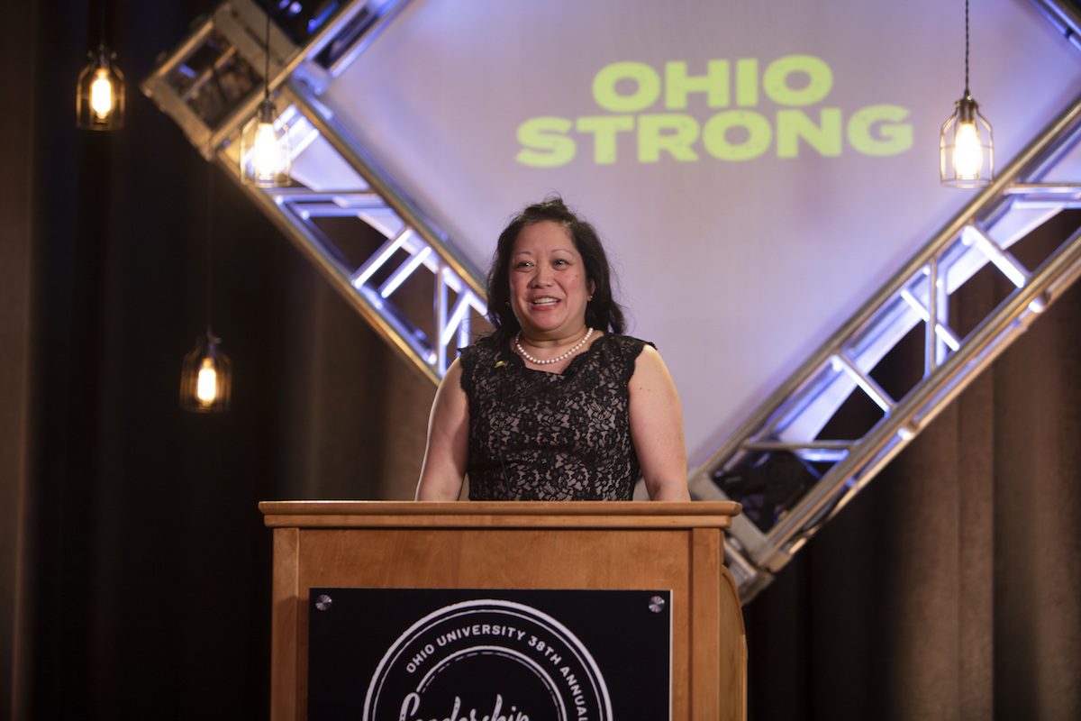 Dr. Gigi Secuban speaks from behind a podium at the Leadership Awards ceremony