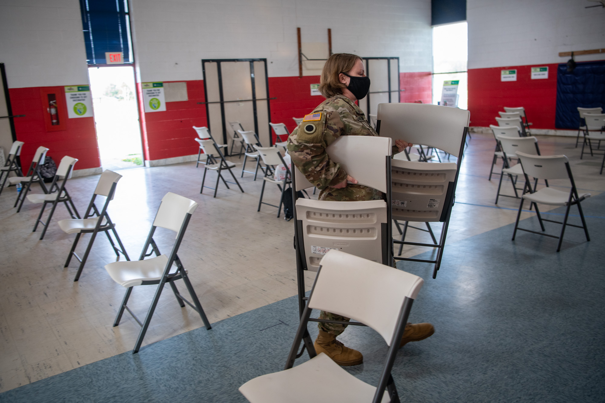 A National Guard medic sets up rows of chairs