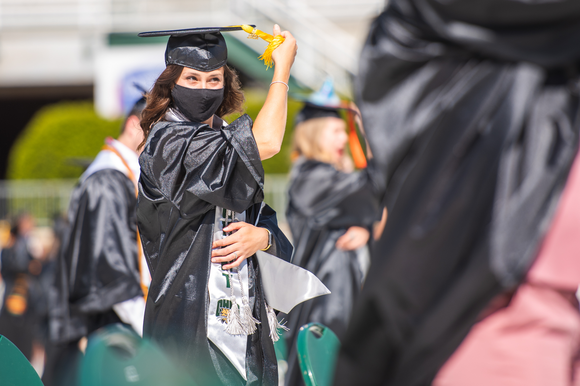 A student flips her graduation cap tassel