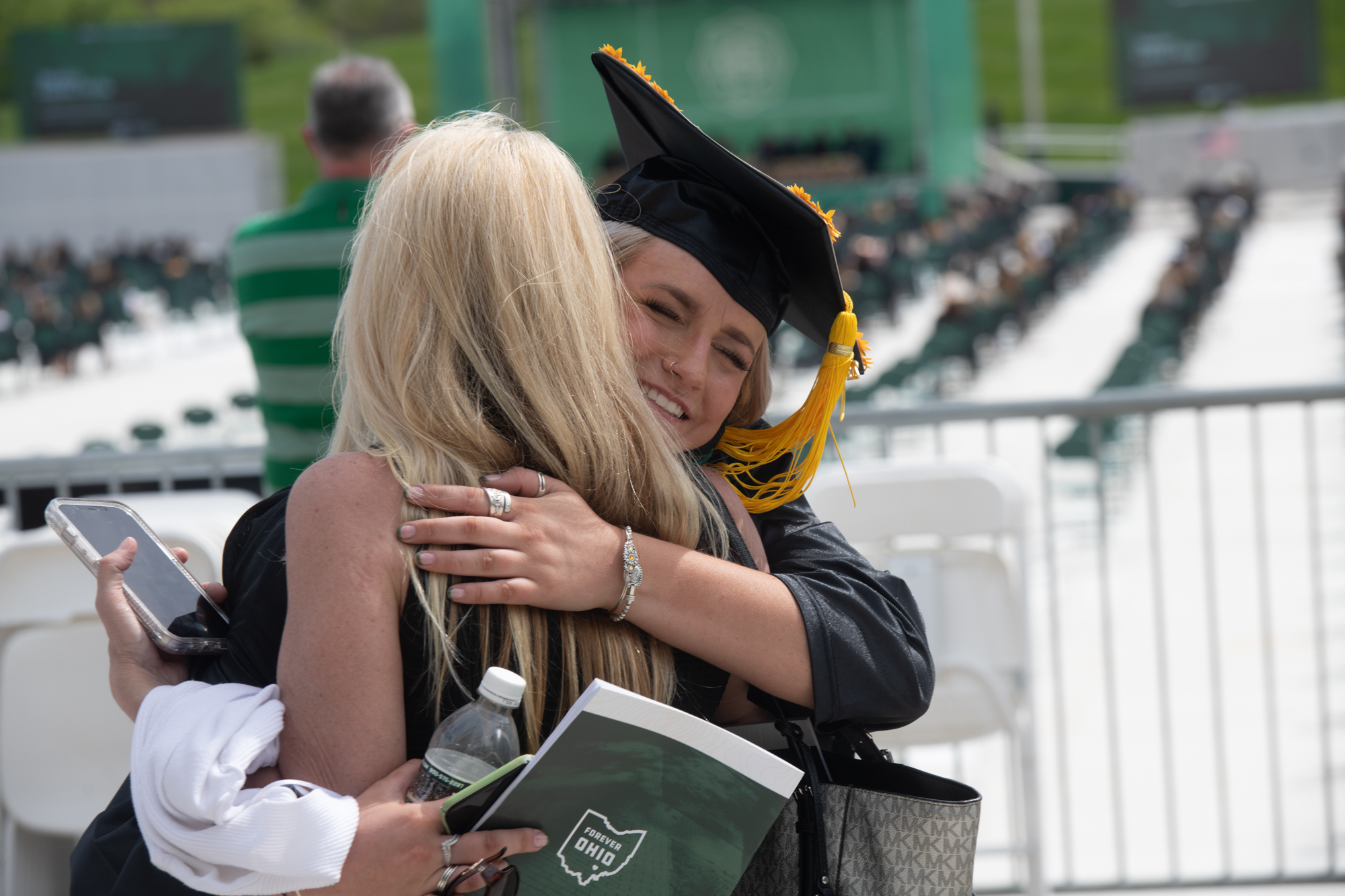 Graduating students hug their friends and family