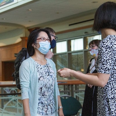 Two women talking with masks on