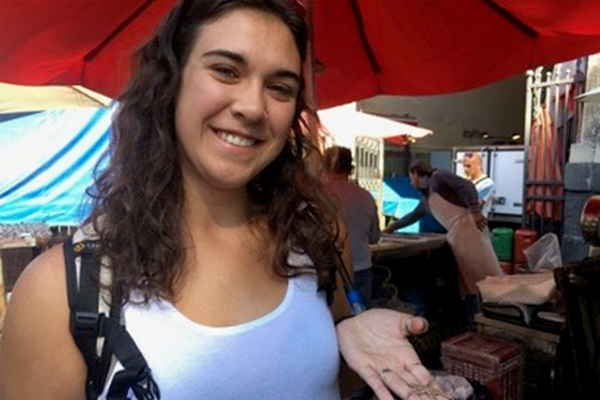 Breanna Oswald is shown holding a tiny starfish at the fish market in Catania, Sicily