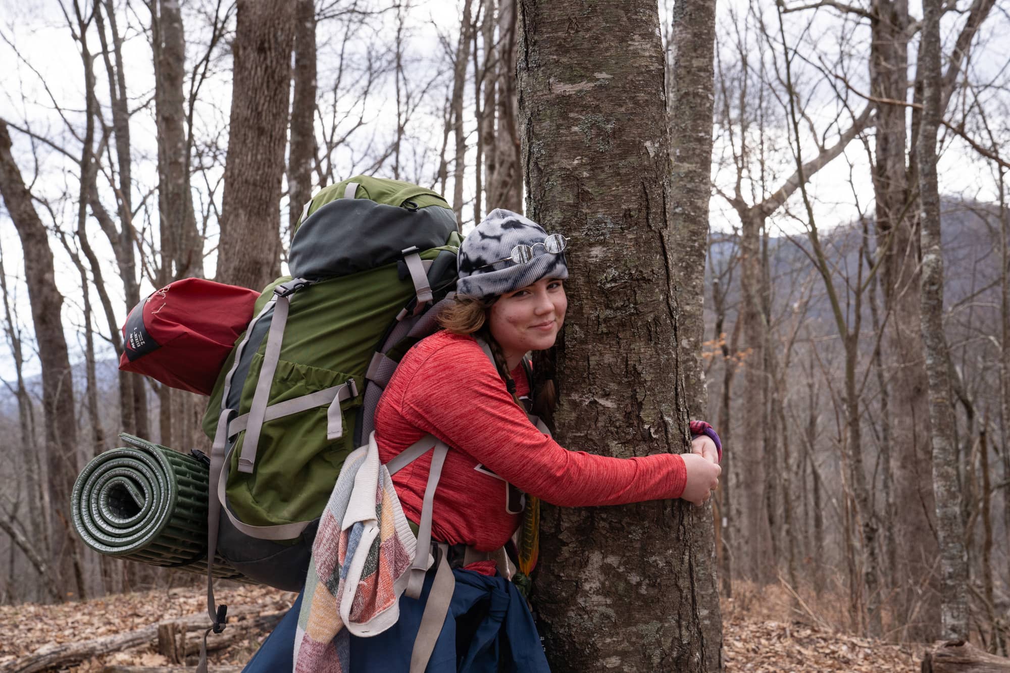 Helena Karlstrom hugs a tree as the group takes a short break during her second day backpacking a section of the Appalachian Trail in the Nantahala National Forest on Sunday, March 6, 2022, near Franklin, North Carolina.