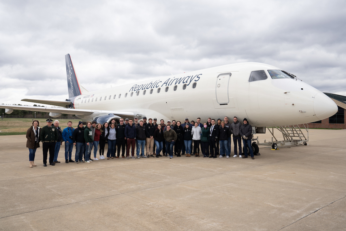 Students, faculty and staff pose with OHIO alumni and pilots next to the Republic Airways passenger jet.