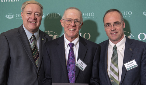 Former OU President M. Duane Nellis, James Stratman, and Dean Florenz Plassmann standing in front of an OU background
