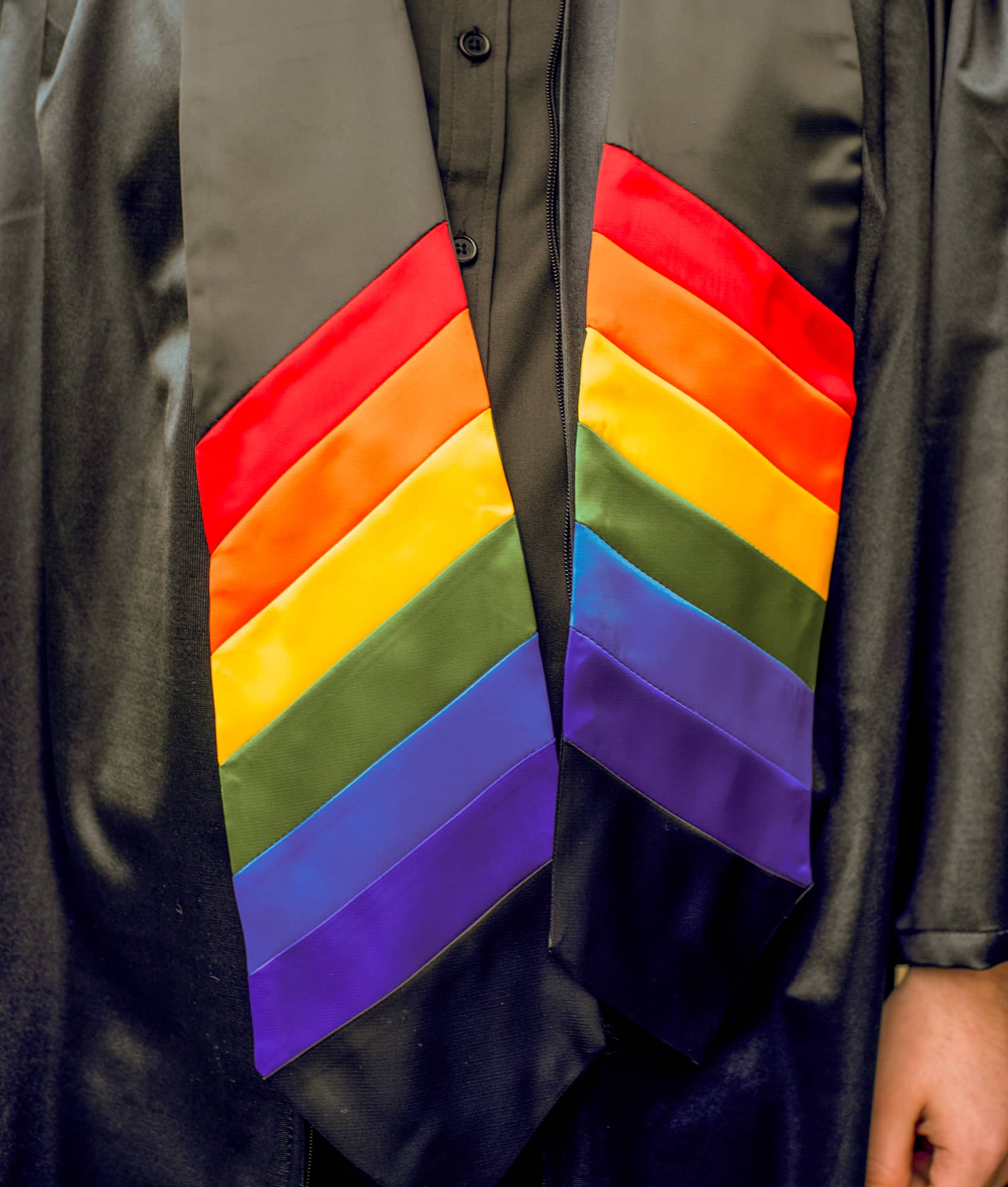A student wears a rainbow honor stole at graduate commencement.