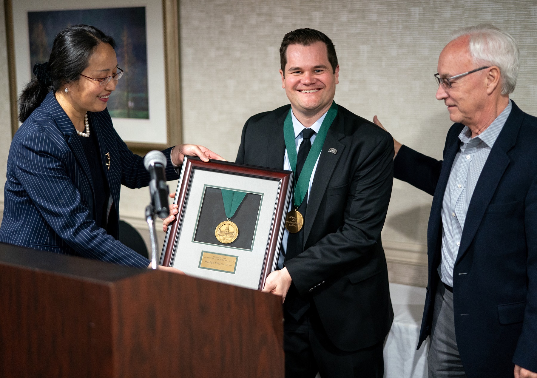 a.	Jake Sigal, MSISE ’04 and BSISE ’03, poses with his plaque, Dean Wei and President Sherman