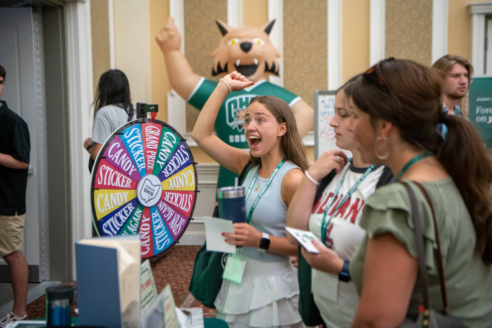 A student reacts after winning the grand prize from a wheel at the University Libraries table during the Bobcat Student Orientation Resource Fair.