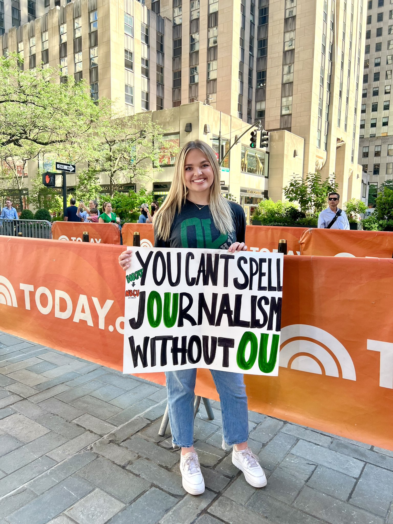Lexi Lepof holds a sign at NBC during National Intern Day. 