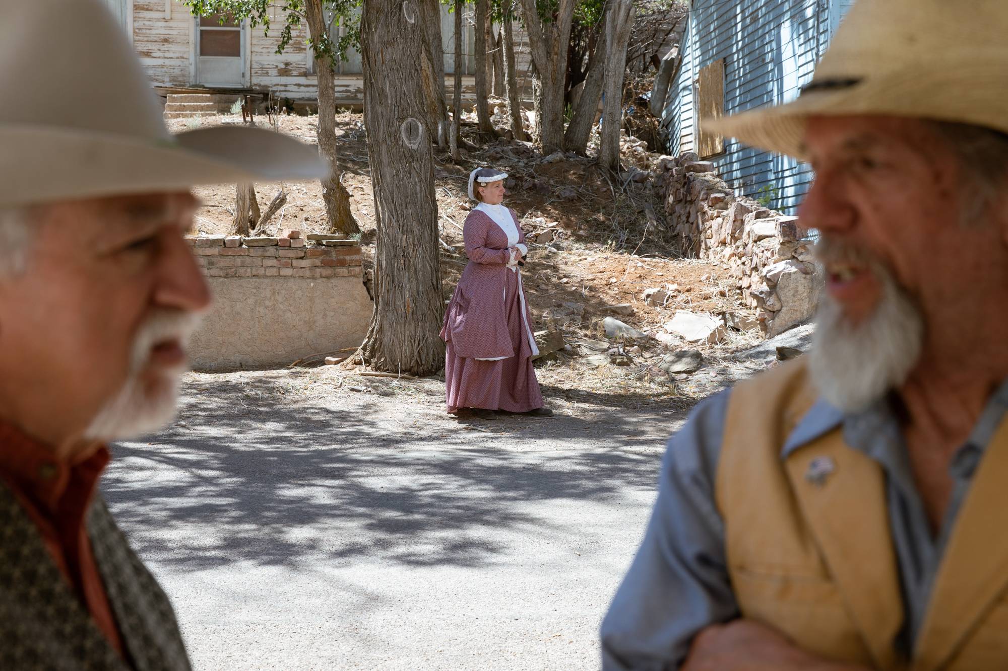 Sharron Faehling, background, Tim Umina, left, and Bill Merfy, right, wait outside of Christ Episcopal Church during filming an 1800s western documentary on Friday, June 24, 2022, in Pioche, Nevada.