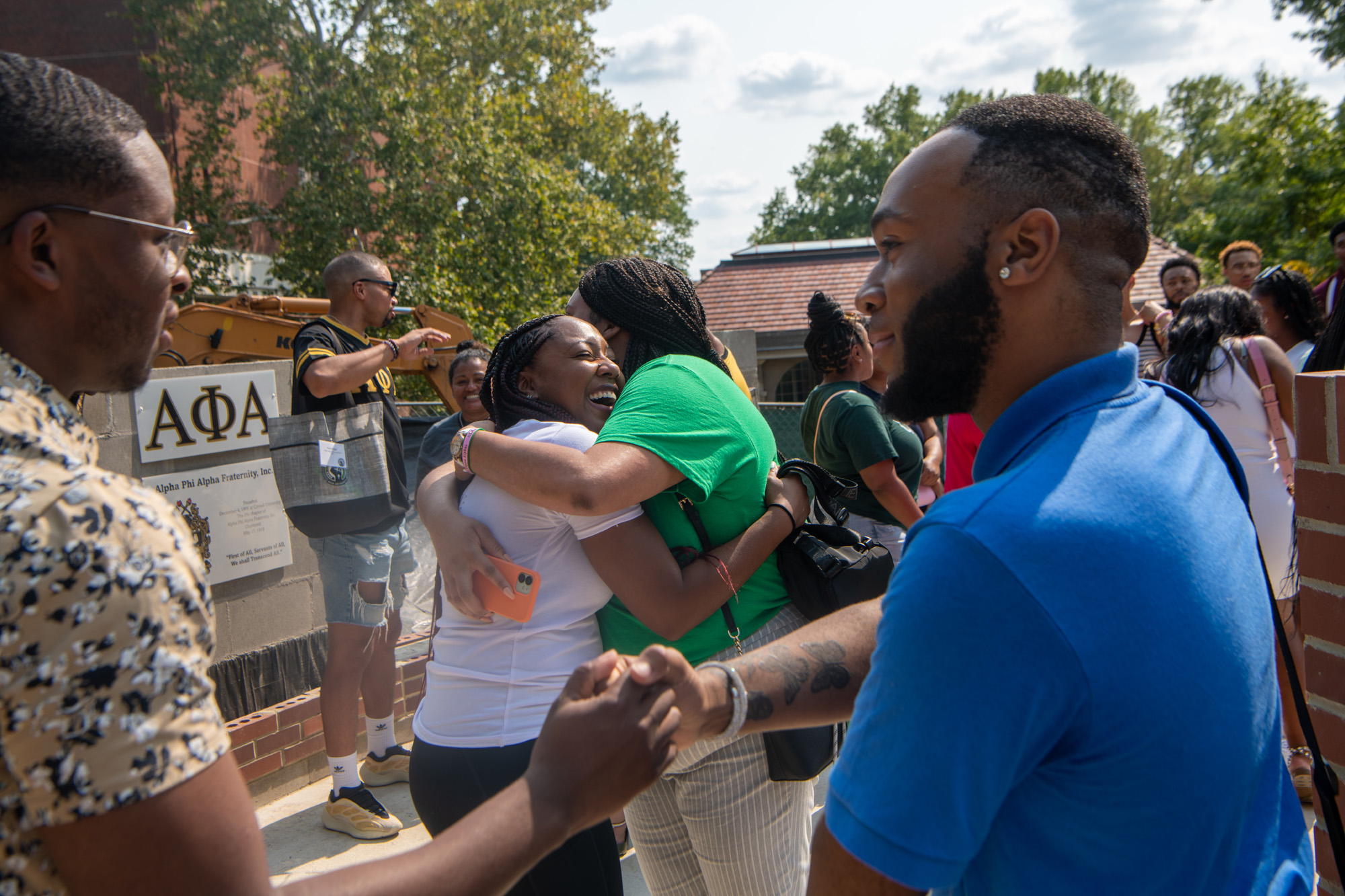 Students and alumni greet one another at the dedication of the National Pan- Hellenic Council Plaza on College Green.