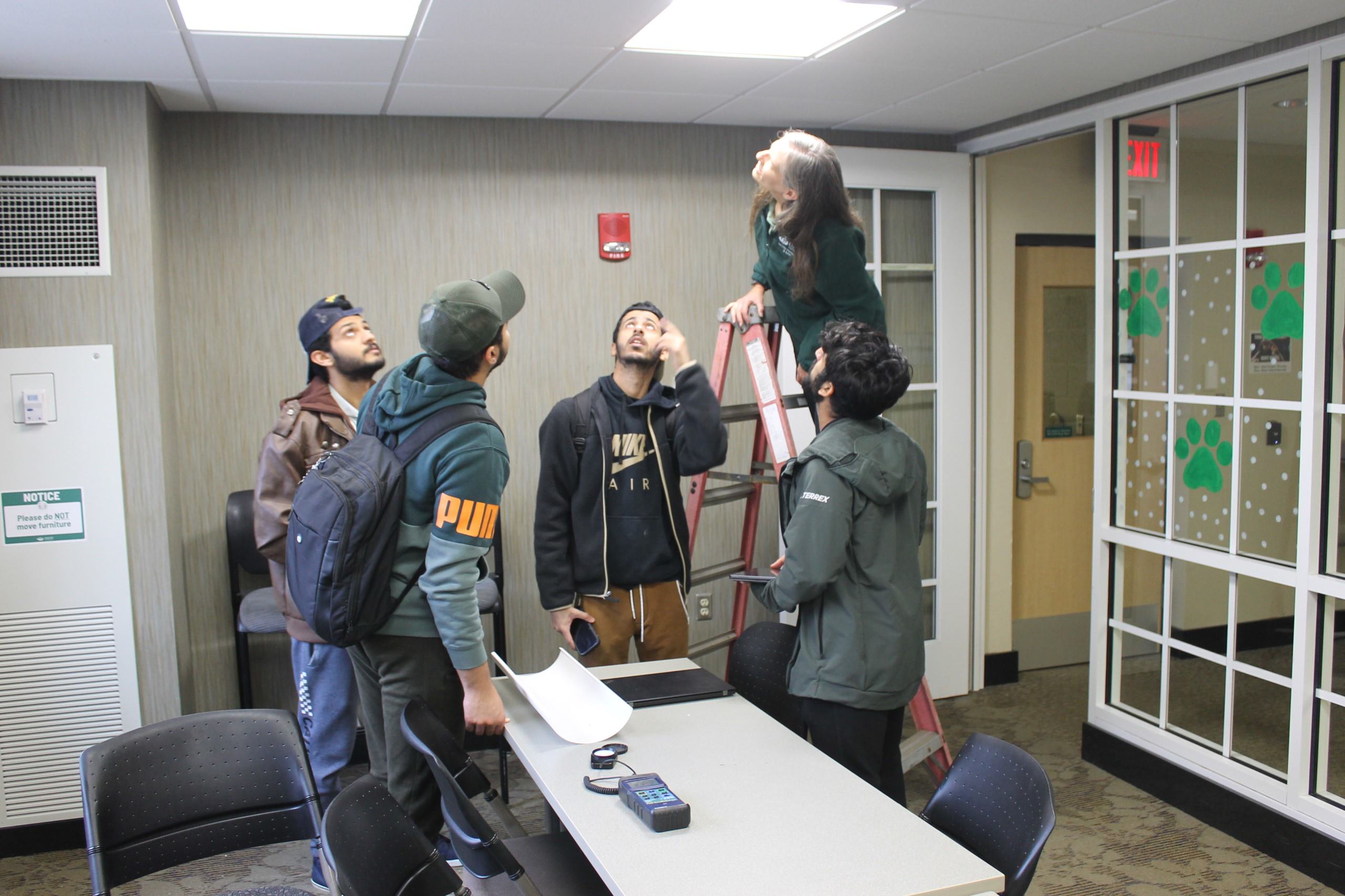 Students check light bulbs in Shively Hall
