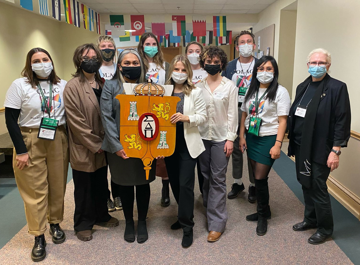 Sigma Delta Pi sponsors the OLAC pizza party and creative readings in 2022, masks still in place. Bottom row from left: María Clara Zanini, Carrie Summerford, Jafet Ix, Grace Weisel, Abby Neff, Diana Contreras, and Dr. Betsy Partyka. Back row from left: Regan Burridge, Paige Wilson, Suzy Aftabizadeh, and Agustín Klaric.
