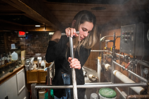 Francesca Carney stirs the mash at the Jackie O's Brewpub.