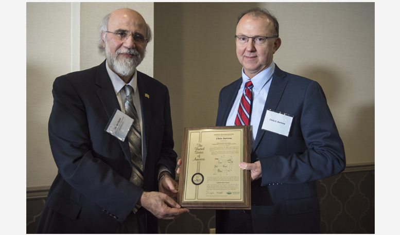Executive Vice President and Provost Chaden Djalali awards Chris Bartone with a U.S. patent plaque.