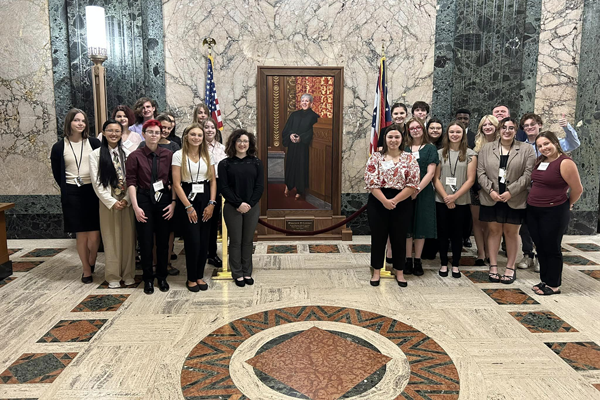 Students pose with a portrait of former Ohio Supreme Court Chief Justice Maureen O'Connor.