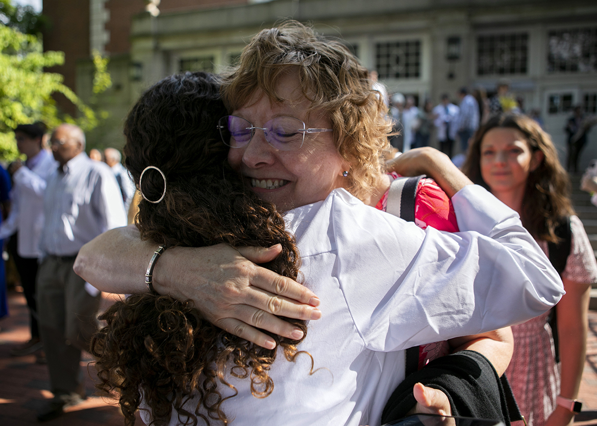 A 2023 HCOM graduate receives a hug following the White Coat Ceremony