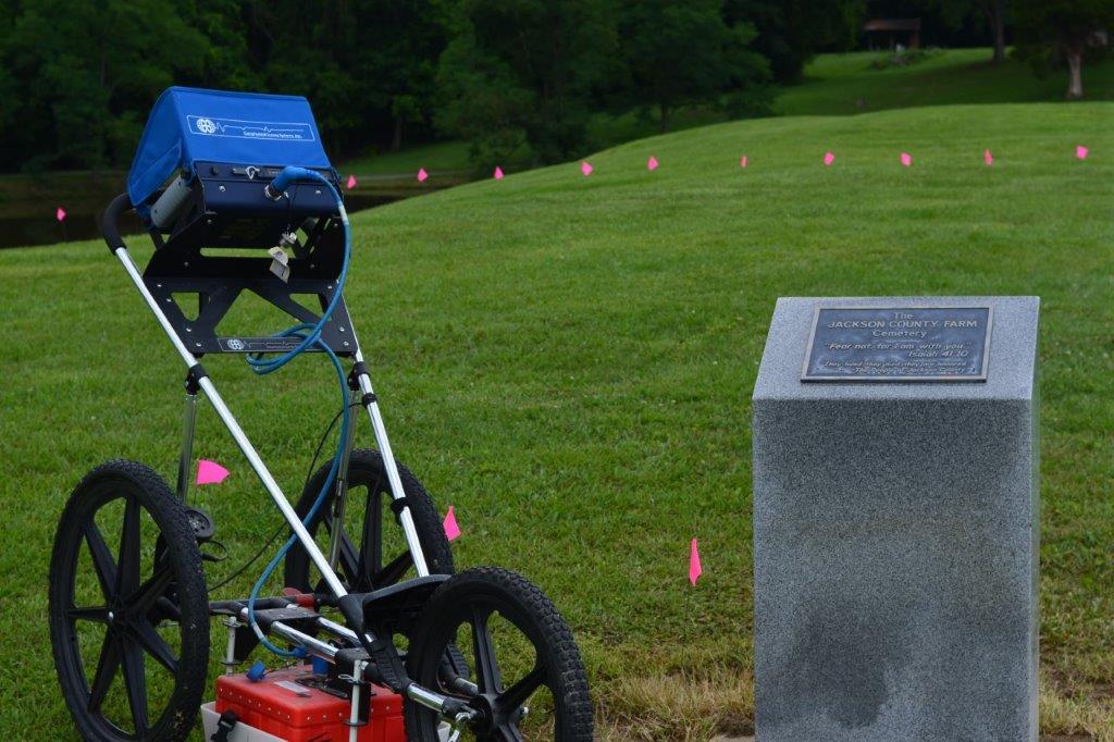 The Ground Penetrating Radar system pictured next to a memorial statue commemorating the Jackson County Cemetery.