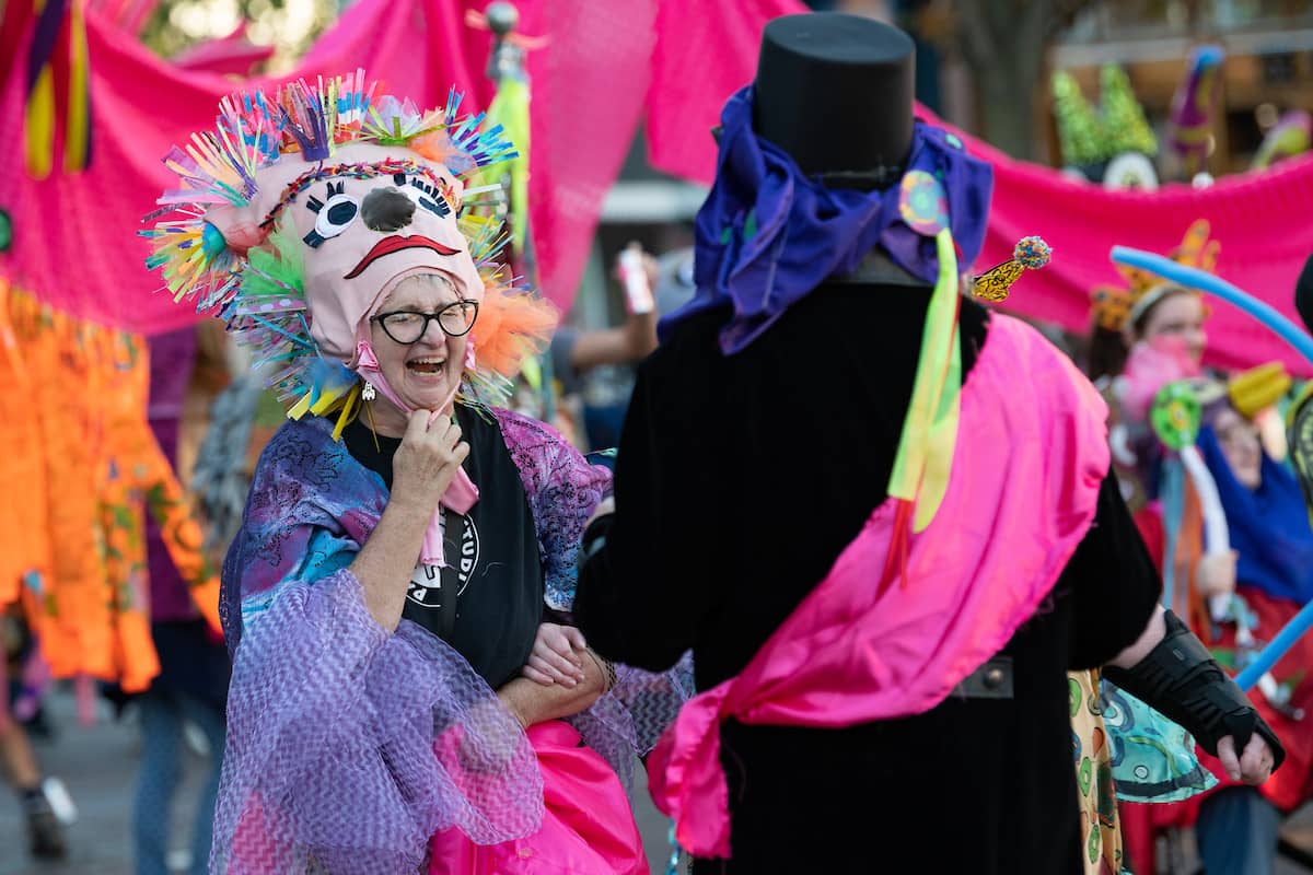 A member of the 2022 Honey for the Heart parade laughs as the parade makes its way down Court Street in Athens, Ohio.