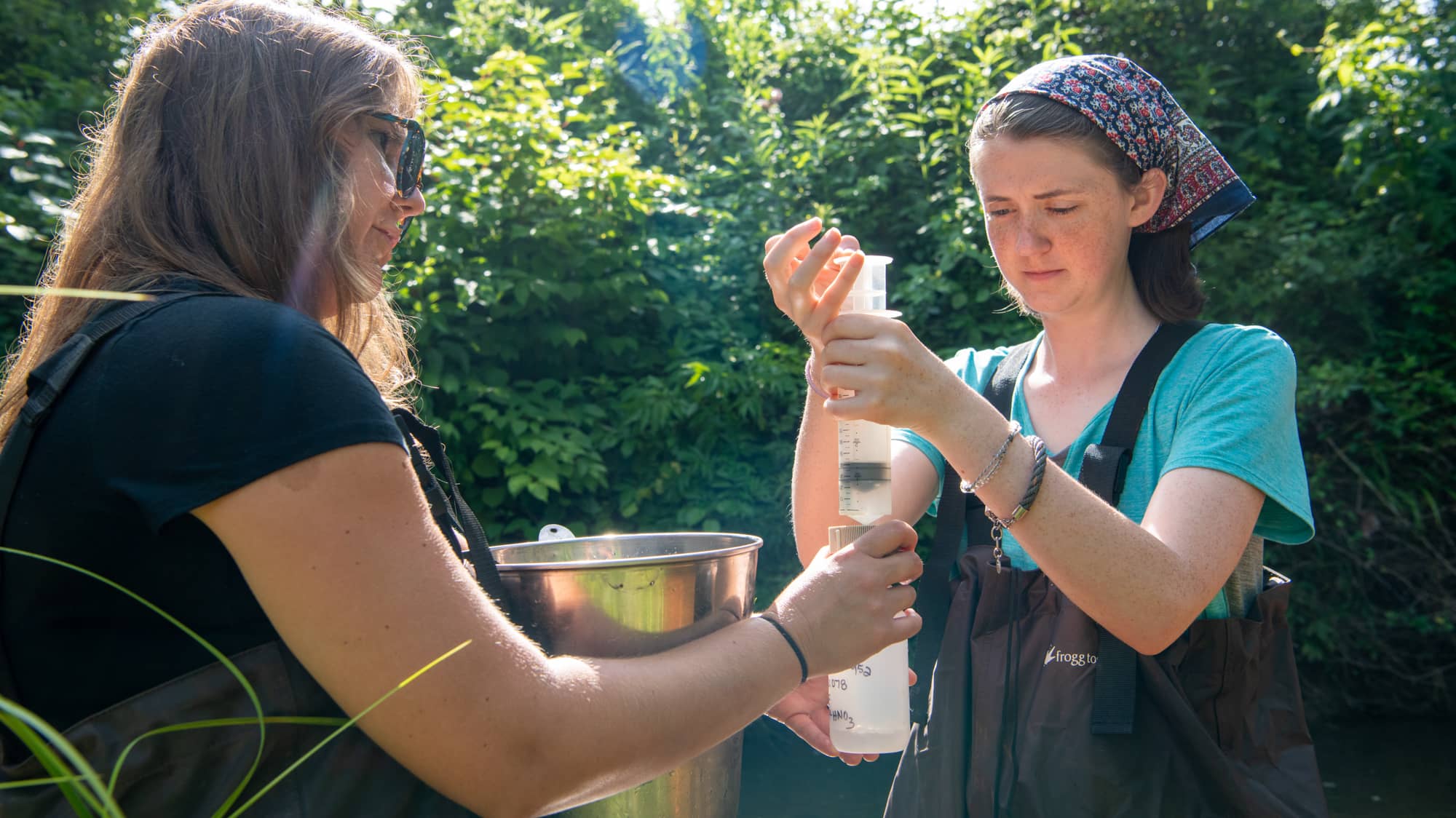 Michelle Shively (left) of Rural Action instructs undergraduate engineering student Liz Myers on how to evaluate stream health at an acid mine drainage site near Athens. 