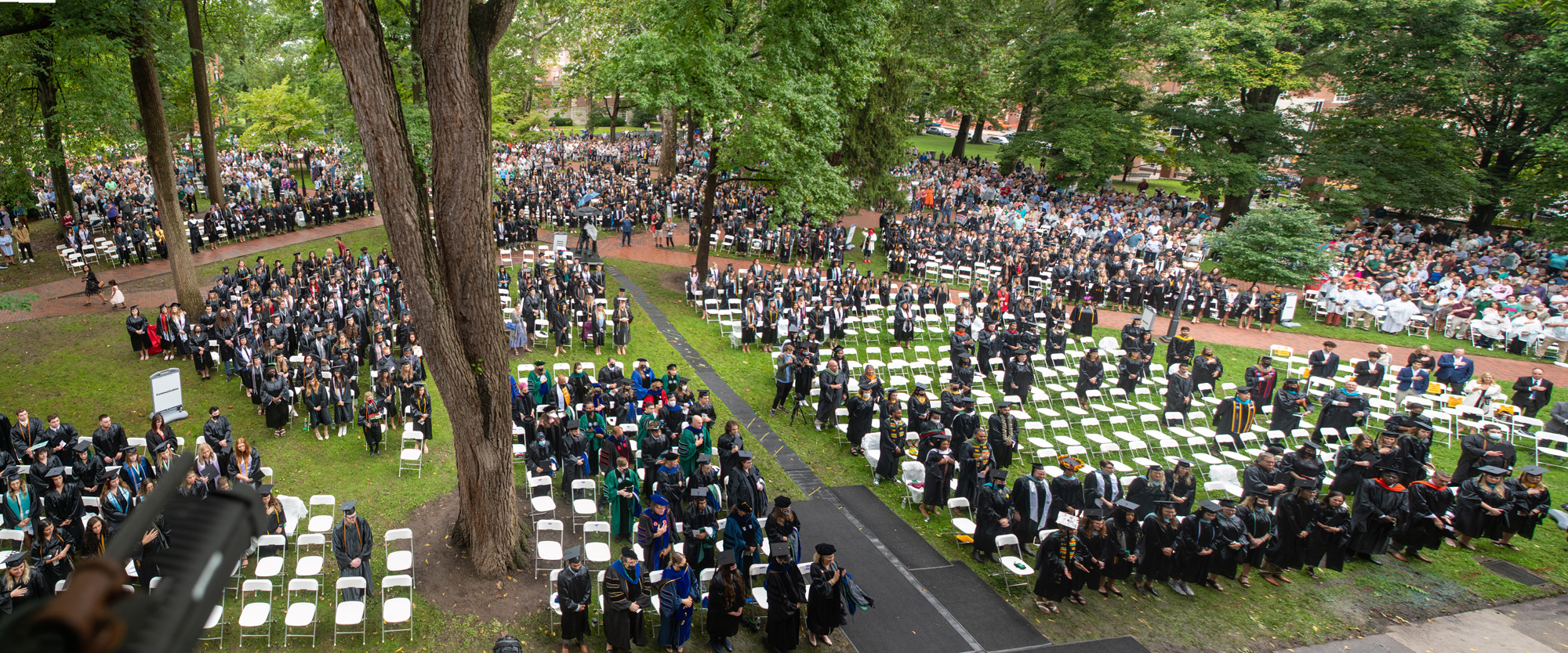 Graduating students are seated across College Green
