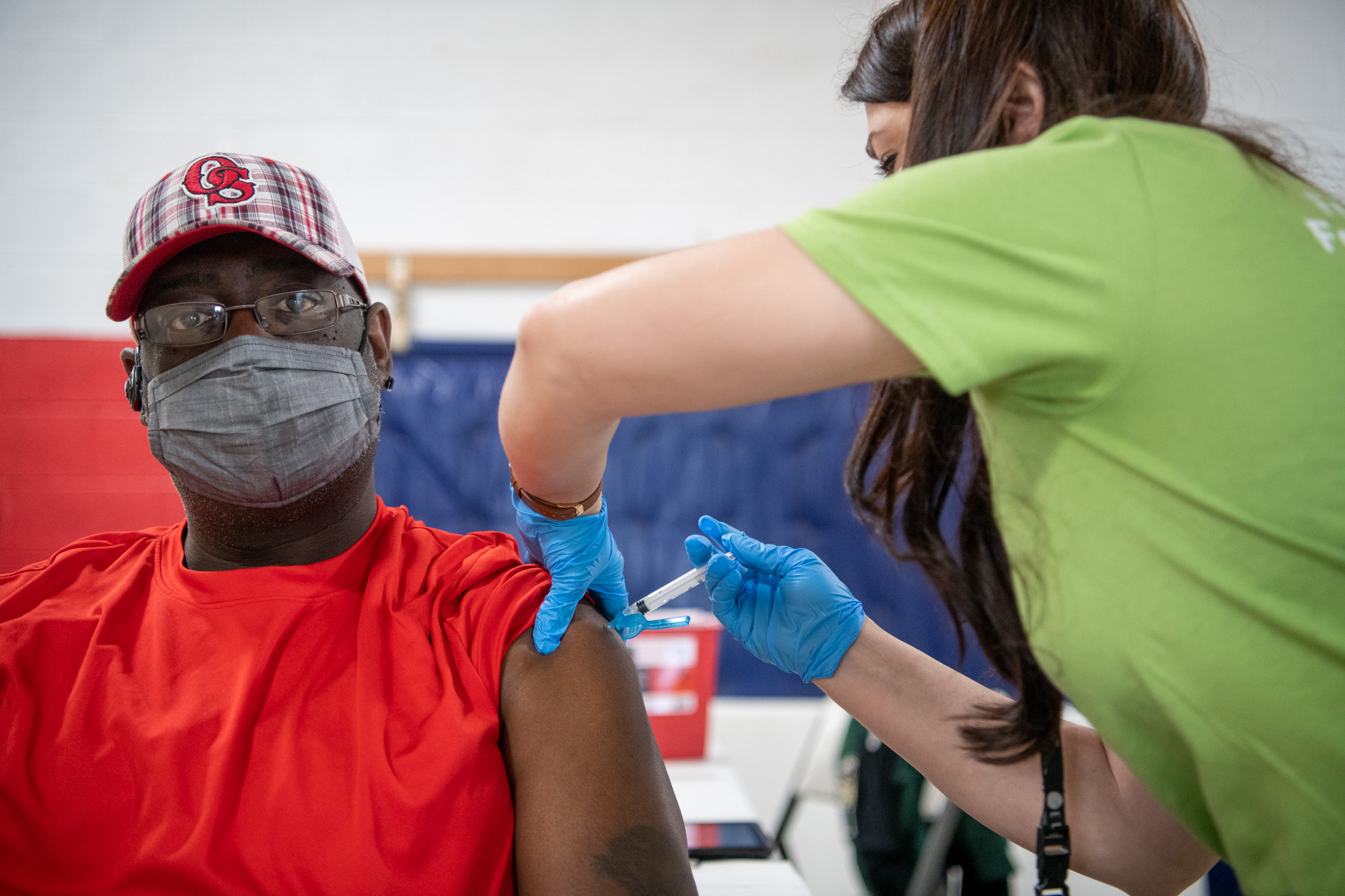 A man recieves a shot in his upper arm
