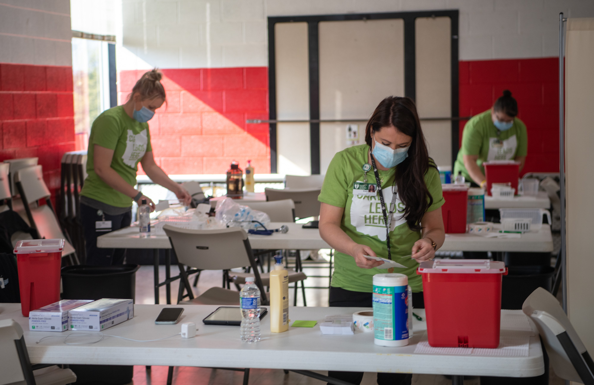 Nurses setting up tables for vaccine administration sites