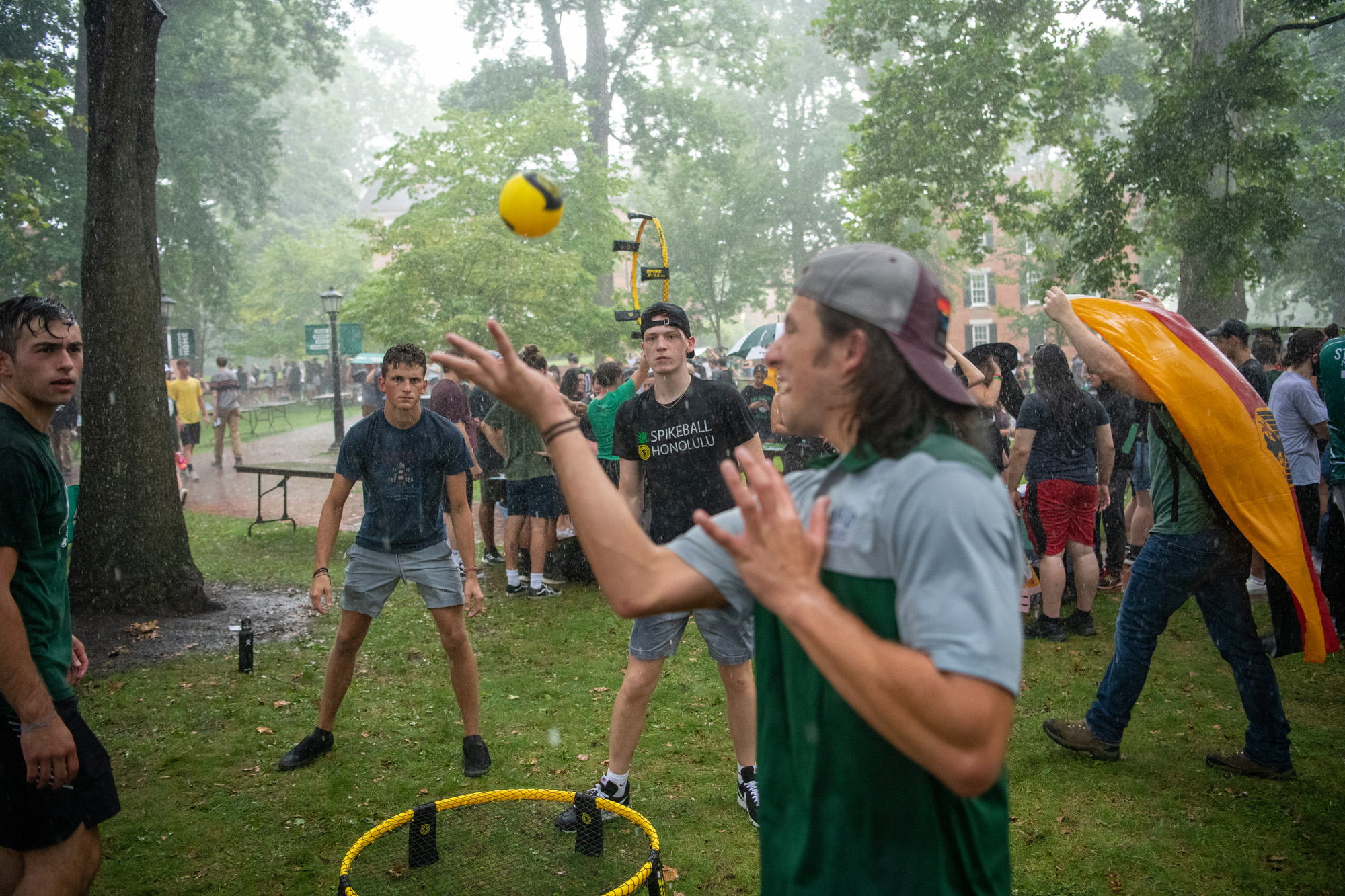 Students enjoy a game of spike ball in the rain on College Green