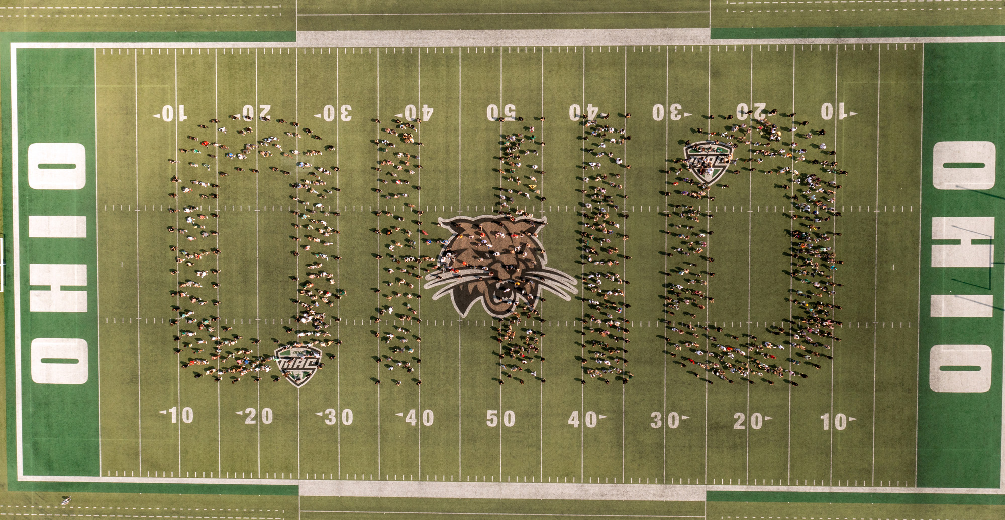 The class of 2024 organized in the shape of OHIO as seen from a drone
