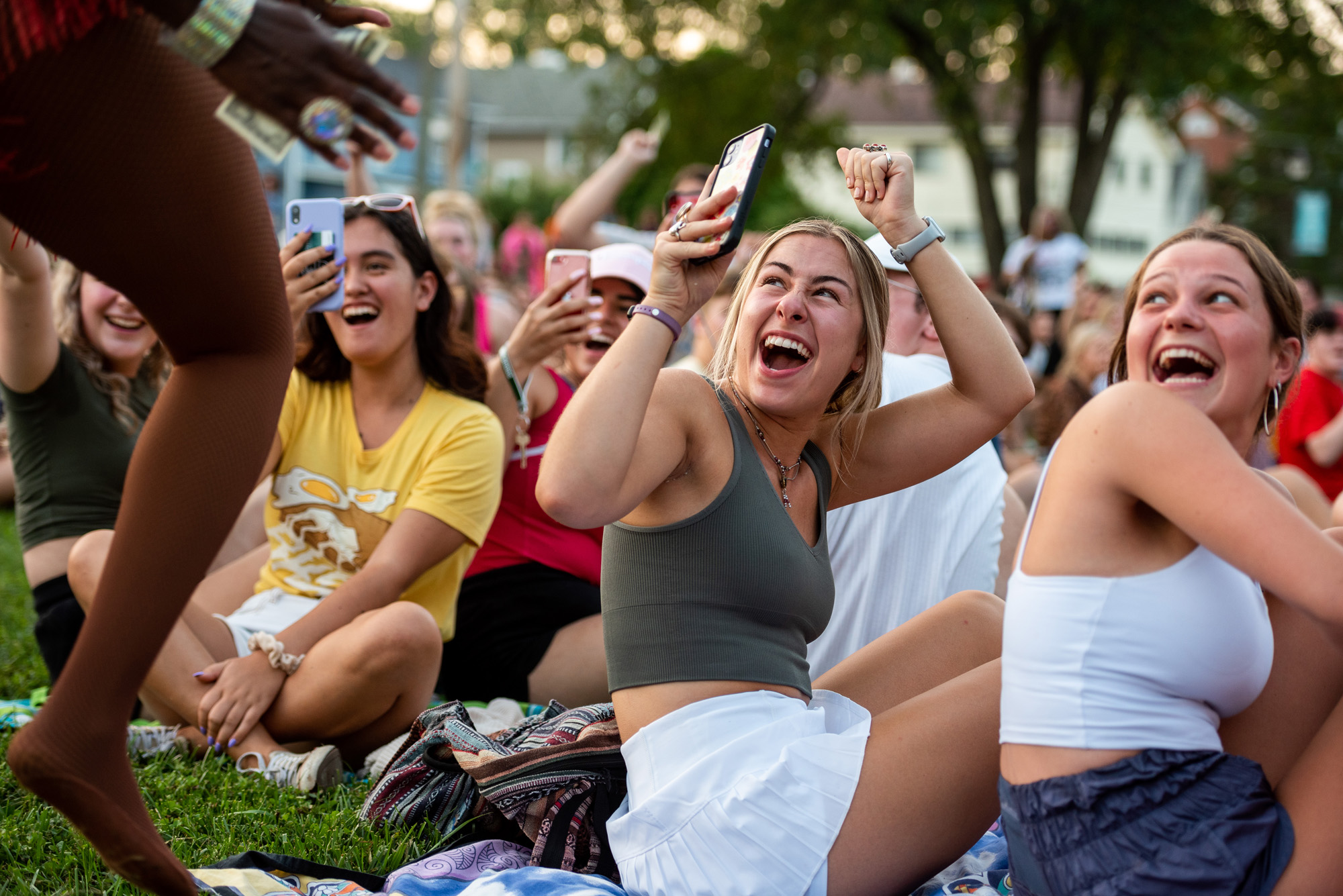 Students react with surprise and take photos of a drag queen on South Green