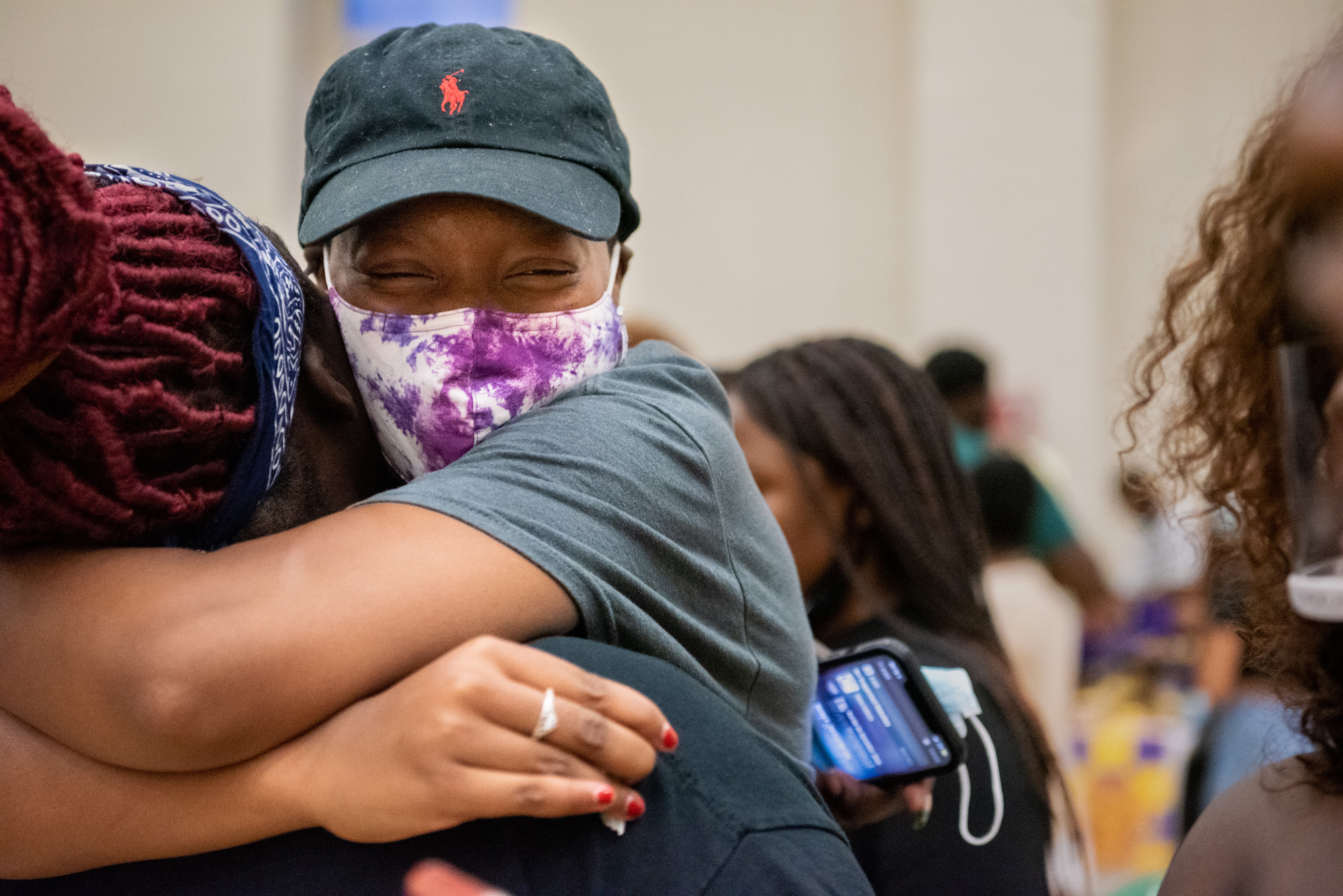 Friends embrace each other happily during the Multicultural Expo