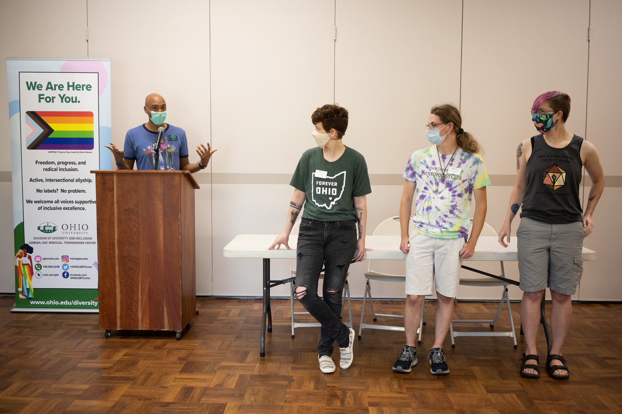The director of the LGBT Center gives a presentation to first year students while three others stand to help facilitate