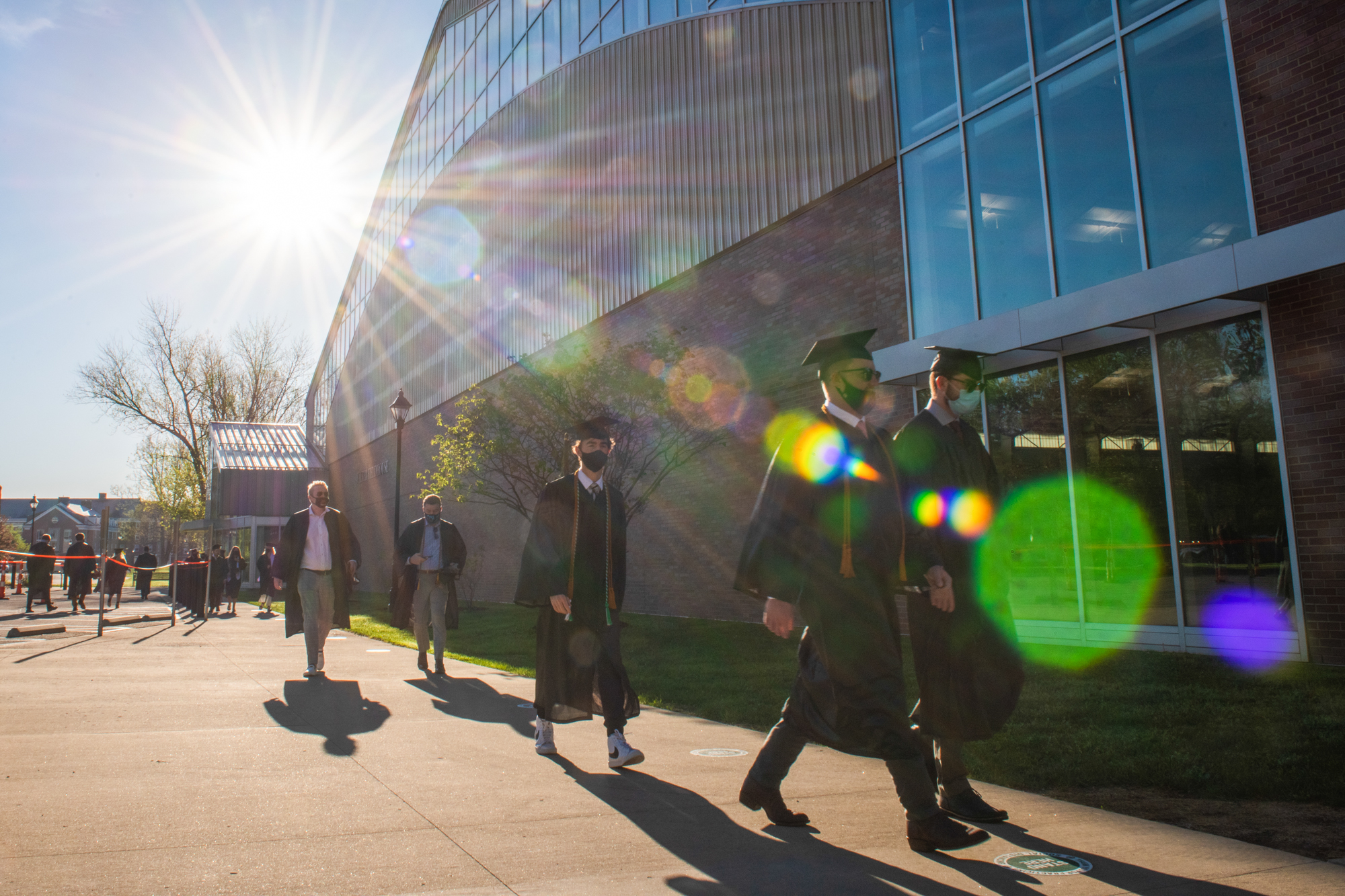 Students walk in cap and gown to the commencement ceremony