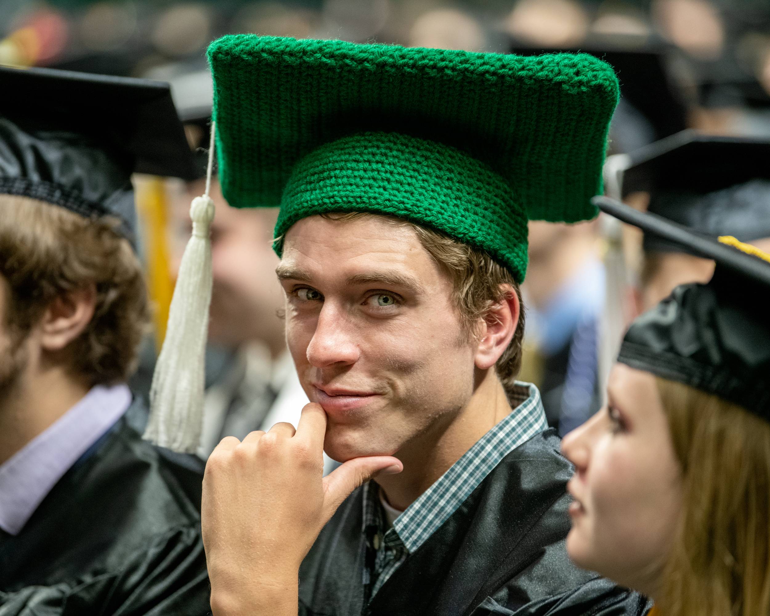 An OHIO graduate wears a knitted cap at graduation.