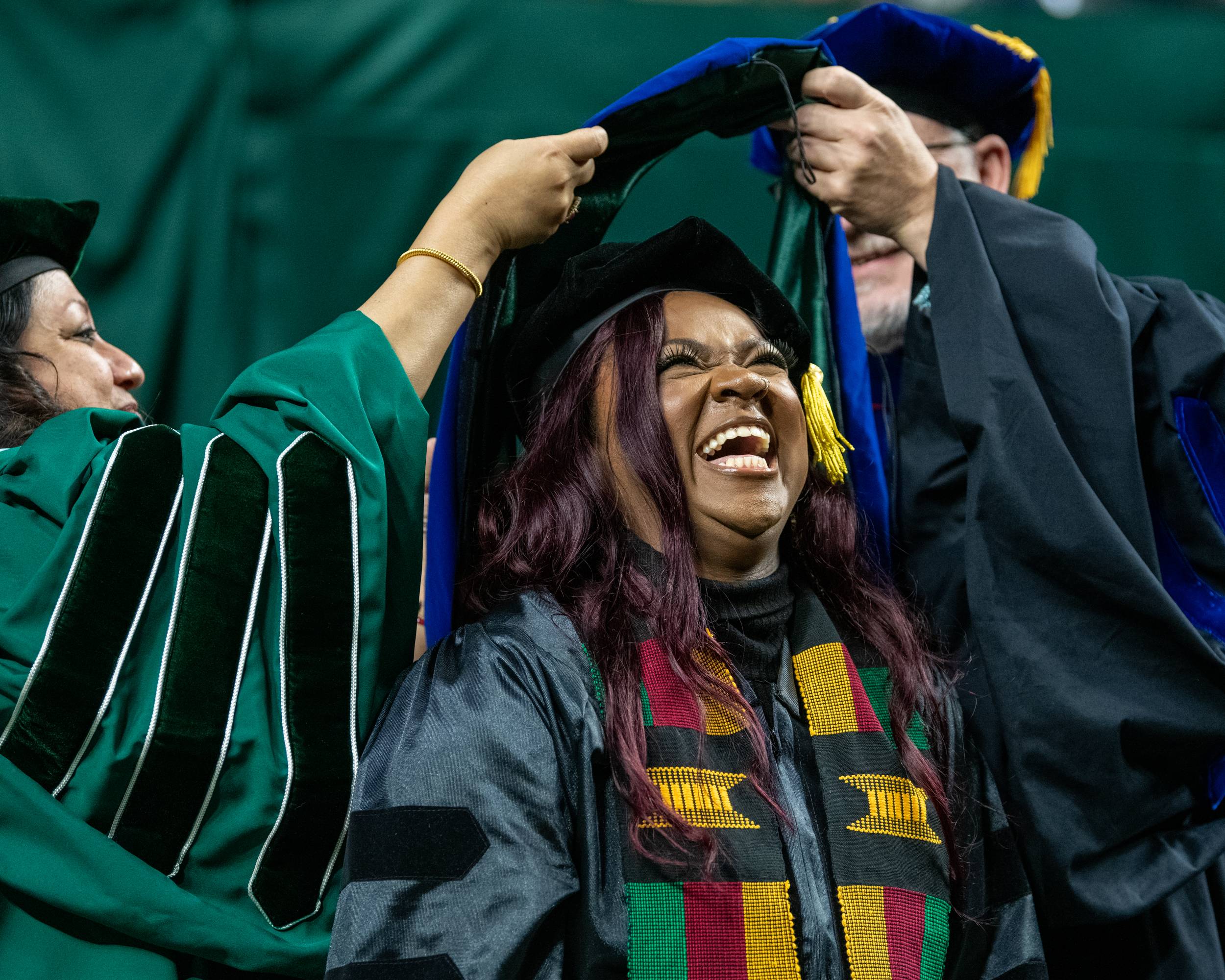 A hood is placed on the doctoral candidate signifying their accomplishment of receiving a Ph.D.