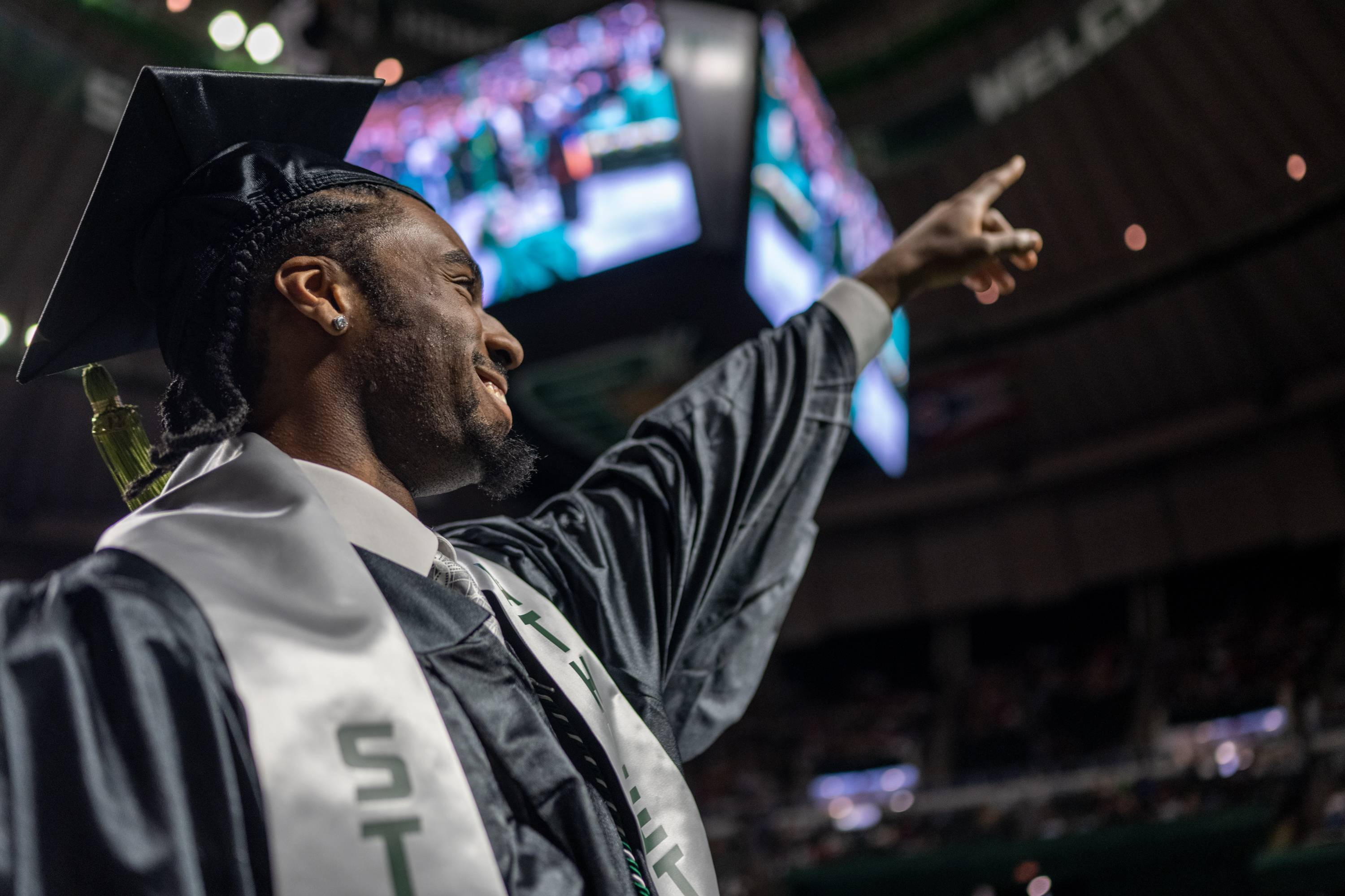 A proud graduate acknowledges the crowd.