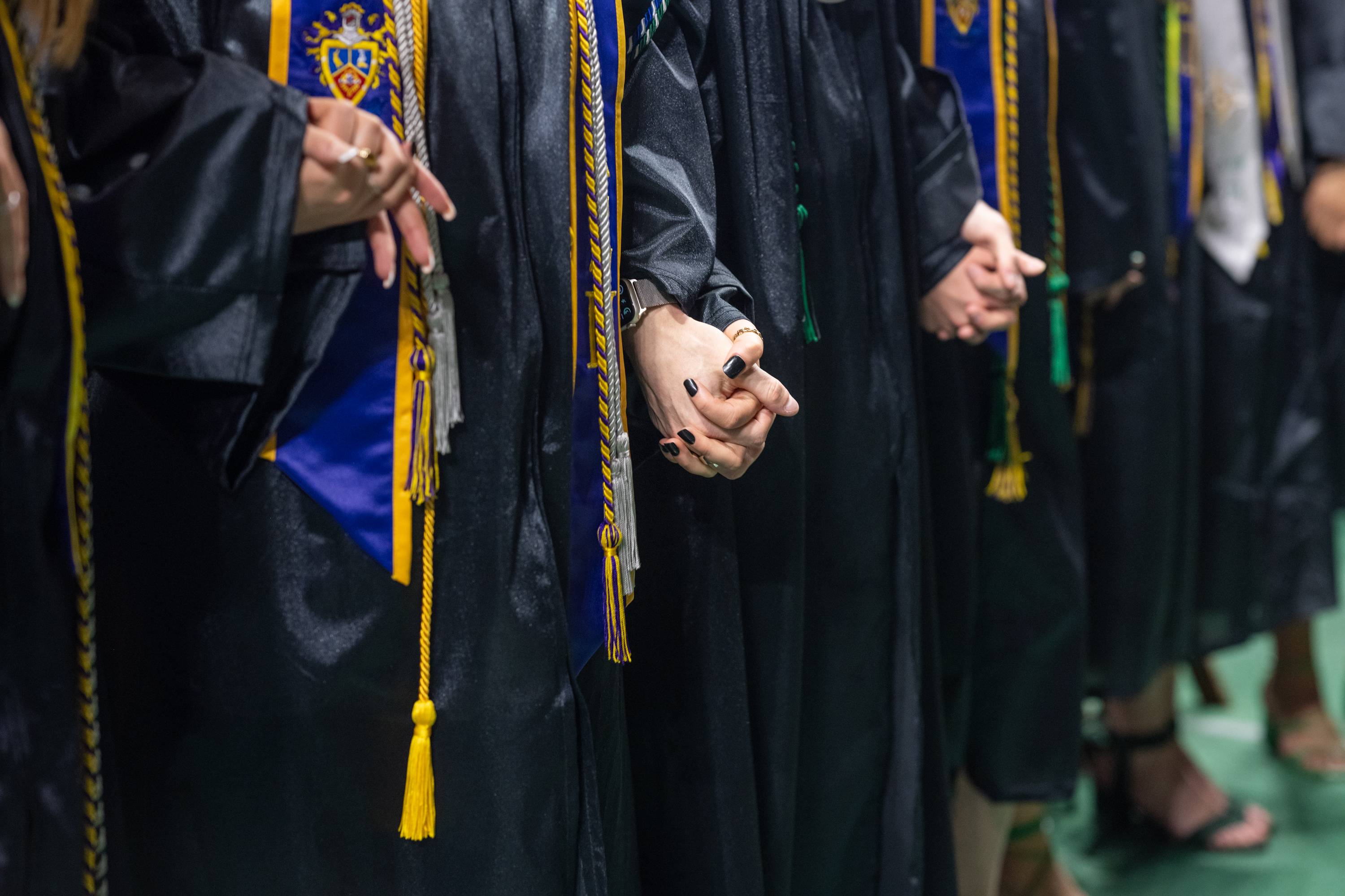 Commencement Speaker David Collins asked the graduates to join hands with those sitting beside them at one point during his remarks and asked them to embrace their differences and their shared human experiences.