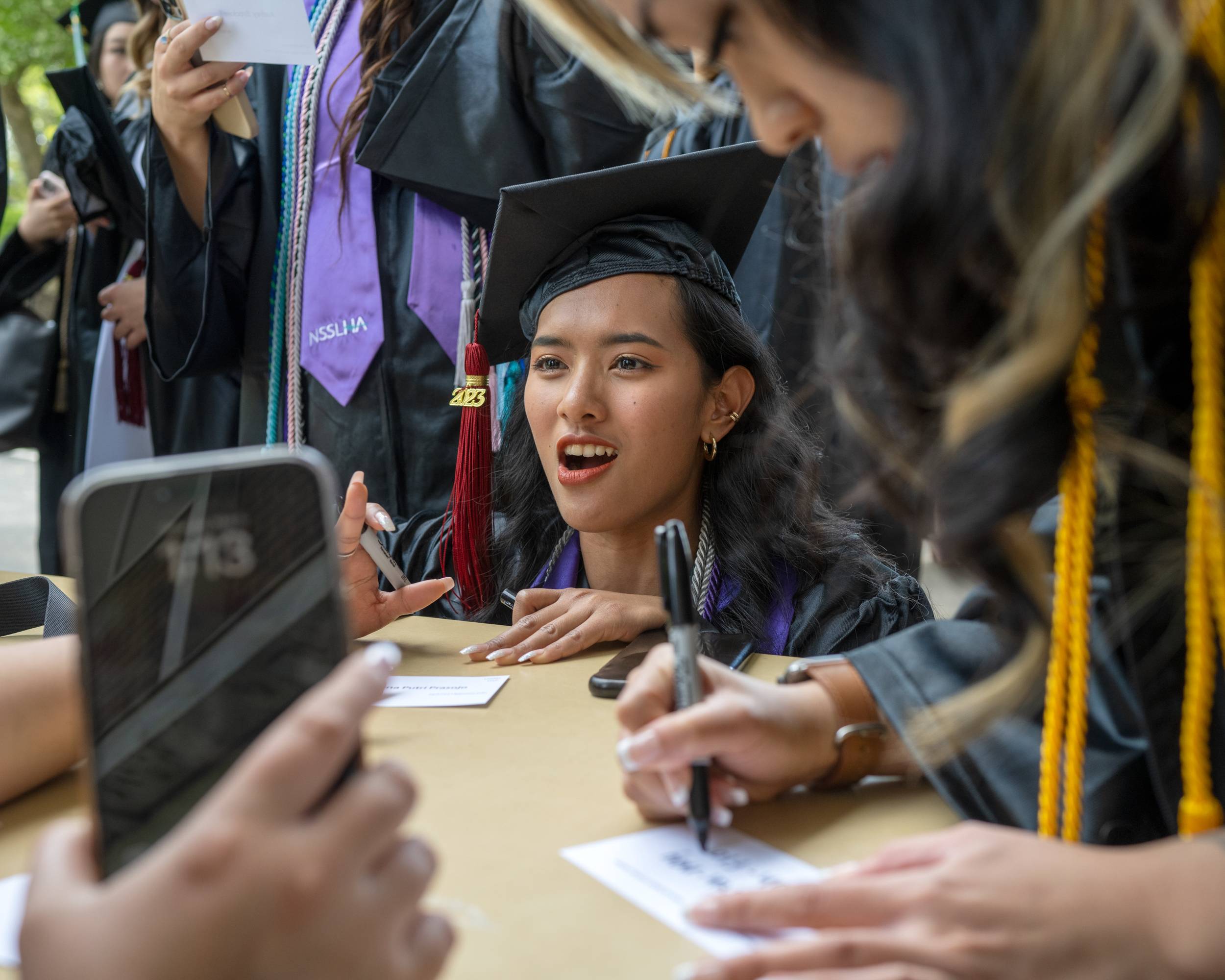 Students prepare for Commencement by receiving their name cards.