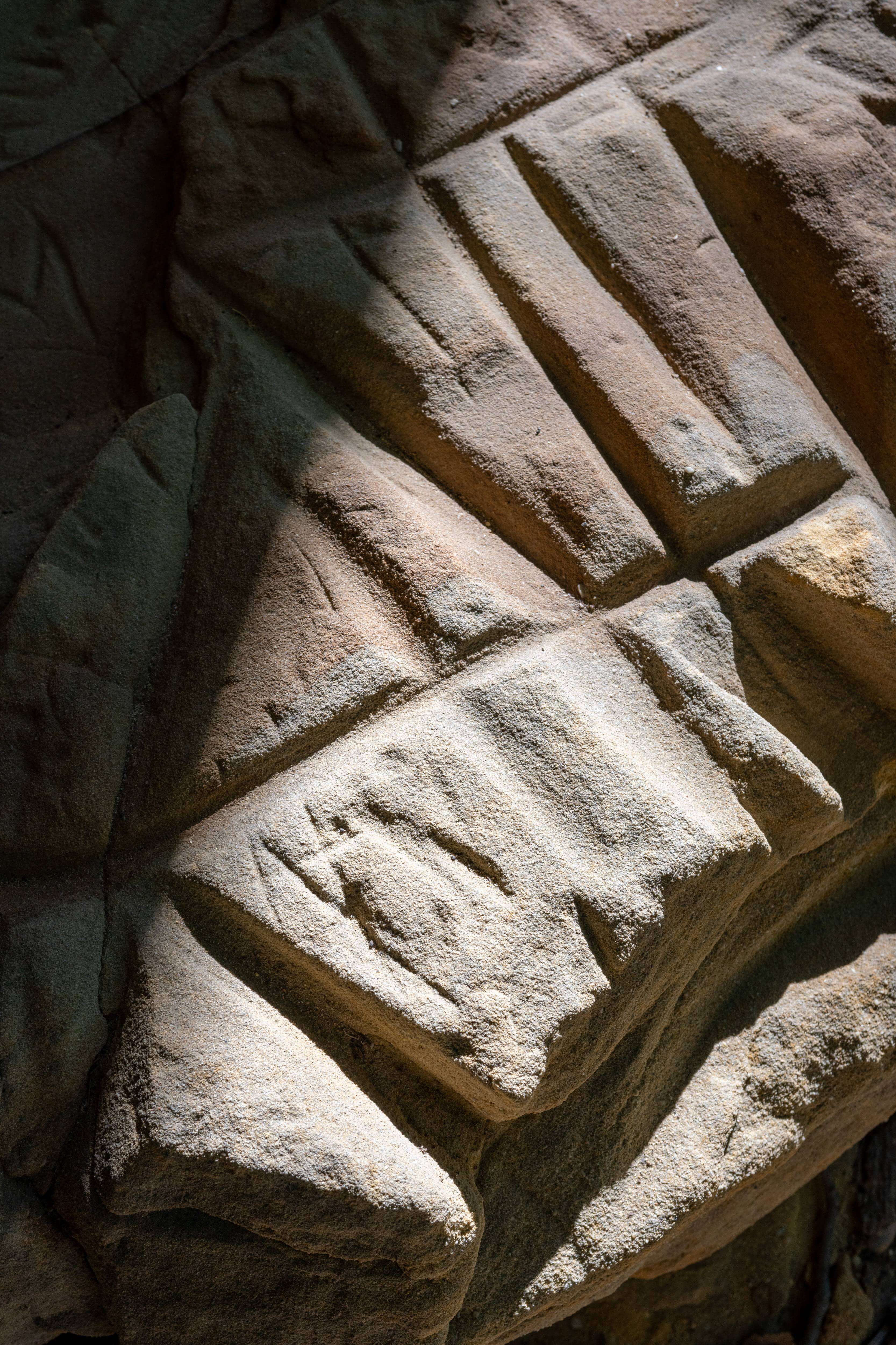 Made by ancient hands: The wall of the rock shelter featured a large stone with grooves used for sharpening stone tools and carvings by ancient Ohioans. Photo by Ben Siegel