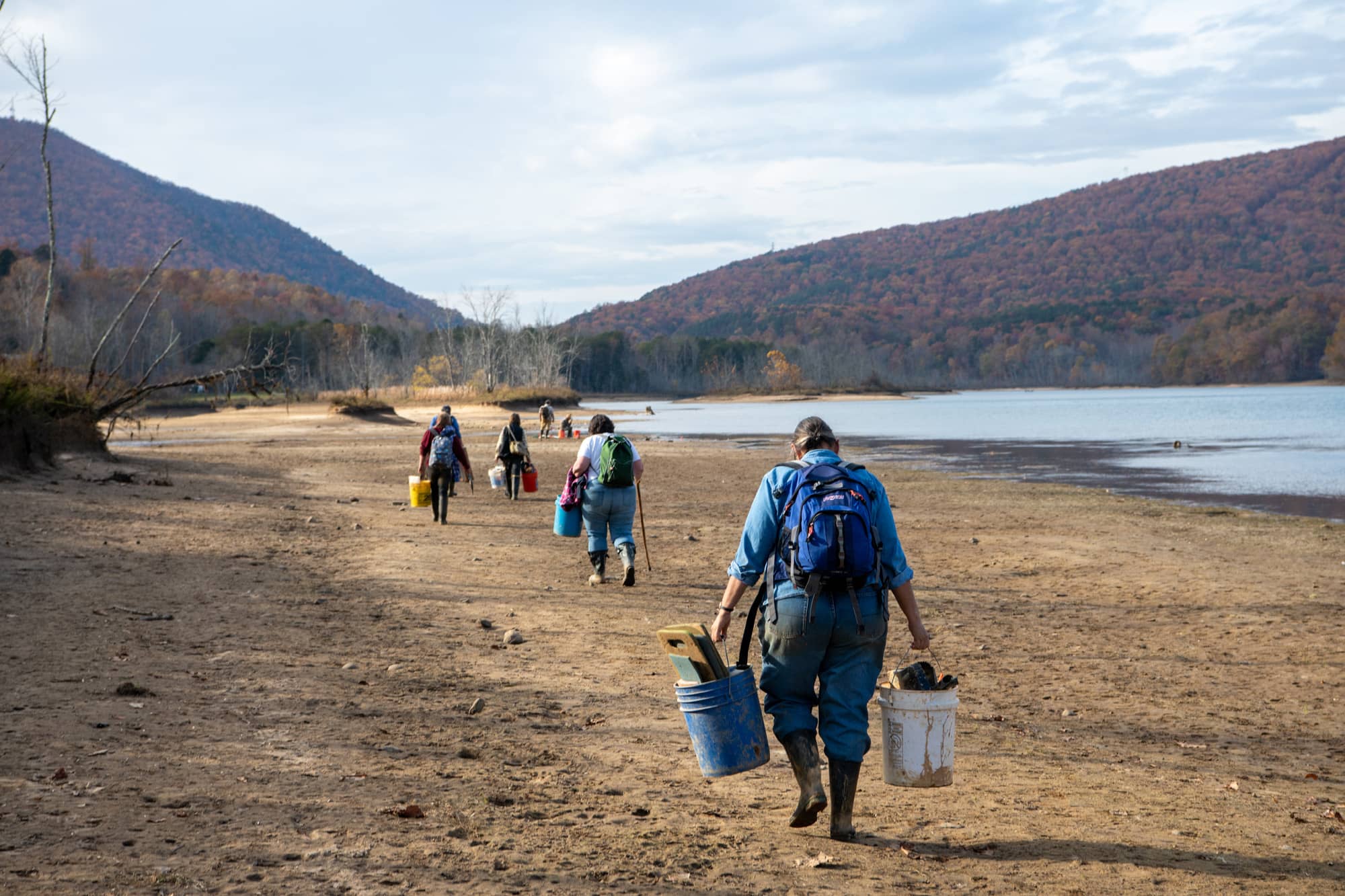 Students and Volunteers carry equipment to excavation areas.