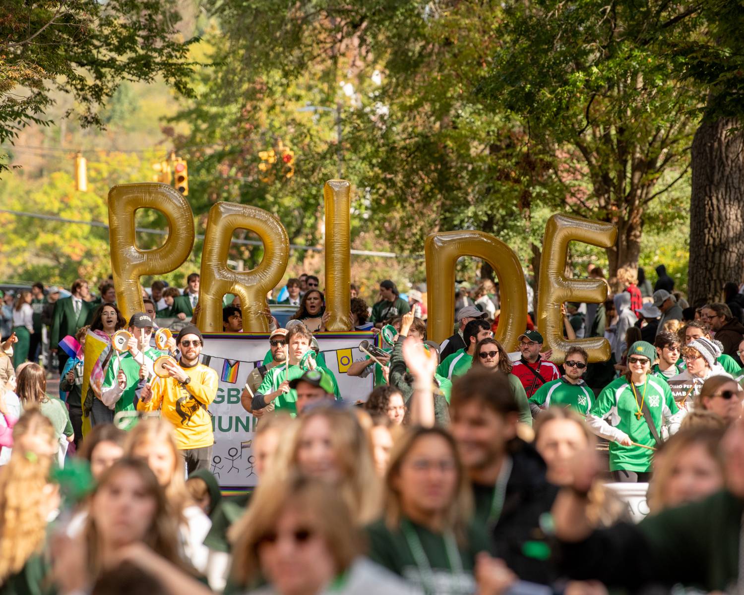 The LGBTQ Community and supporters walk in the Homecoming Parade with a Pride float.